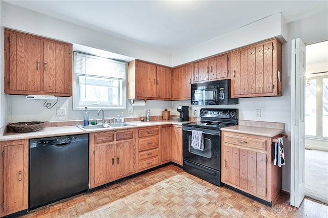 kitchen featuring sink, black appliances, and light parquet floors