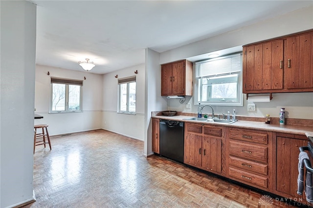 kitchen featuring light parquet flooring, dishwasher, and sink