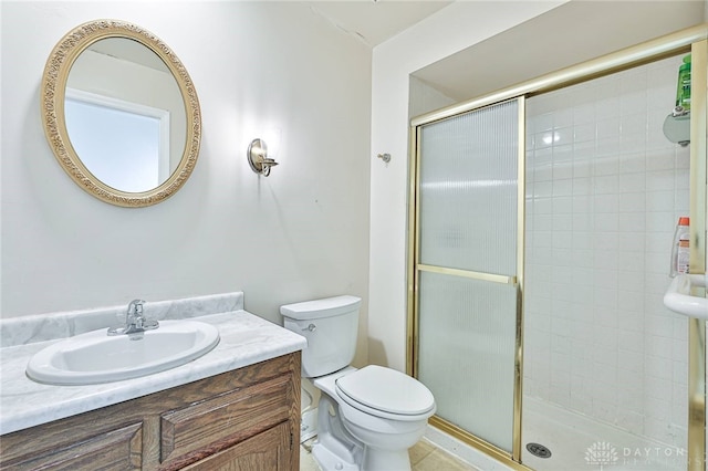 bathroom featuring an enclosed shower, vanity, and toilet