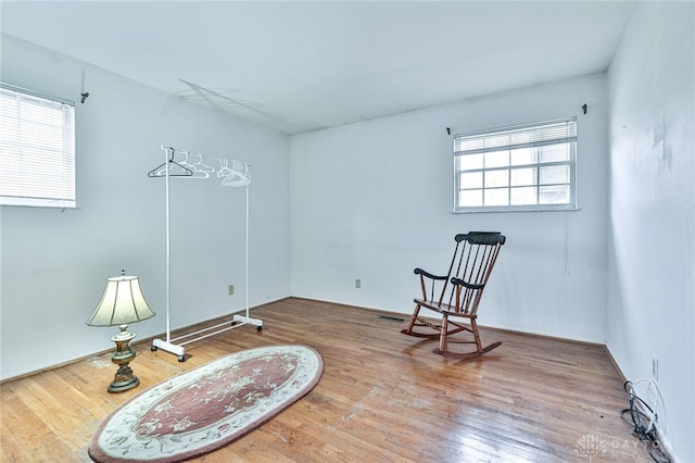 sitting room with a wealth of natural light and wood-type flooring