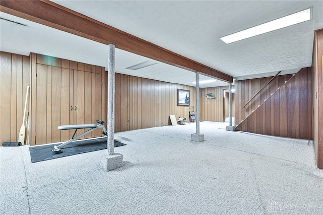 workout room featuring carpet flooring and wood walls