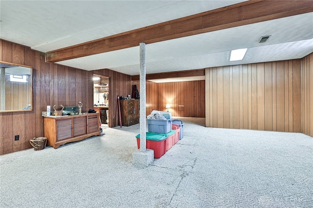 carpeted bedroom with wooden walls and beamed ceiling