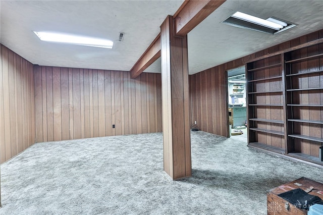 basement with carpet flooring and wood walls