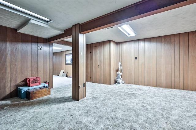 basement featuring carpet floors and wooden walls