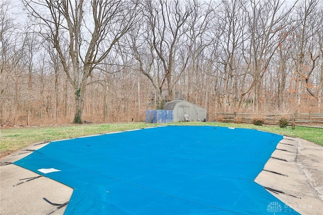 view of swimming pool featuring a storage unit and a diving board