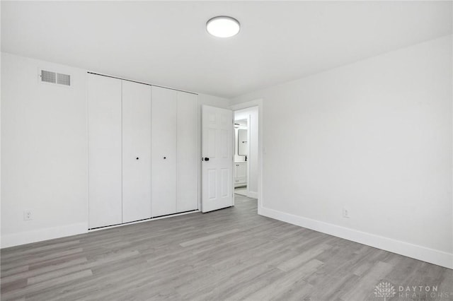 unfurnished bedroom featuring light hardwood / wood-style floors and a closet