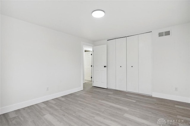 unfurnished bedroom featuring light hardwood / wood-style floors and a closet