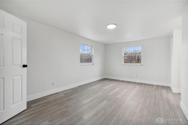 empty room with hardwood / wood-style floors and a healthy amount of sunlight