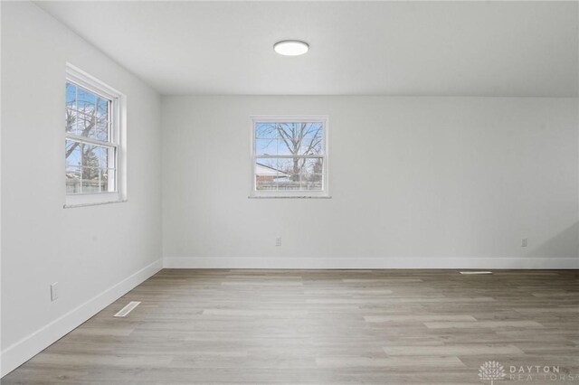 spare room with light hardwood / wood-style floors and a wealth of natural light