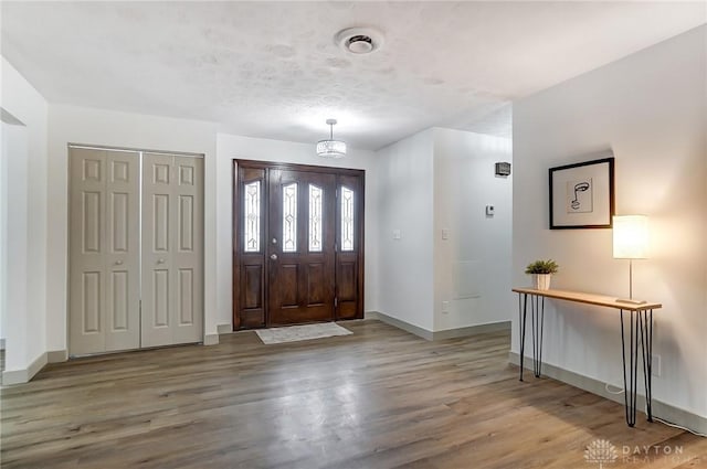 entryway with a textured ceiling and light hardwood / wood-style flooring