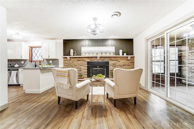 interior space featuring a fireplace, sink, and light hardwood / wood-style flooring