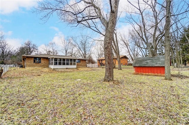 view of yard with a shed and a sunroom