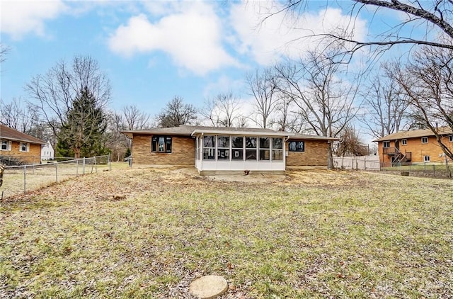 rear view of property with a yard and a sunroom