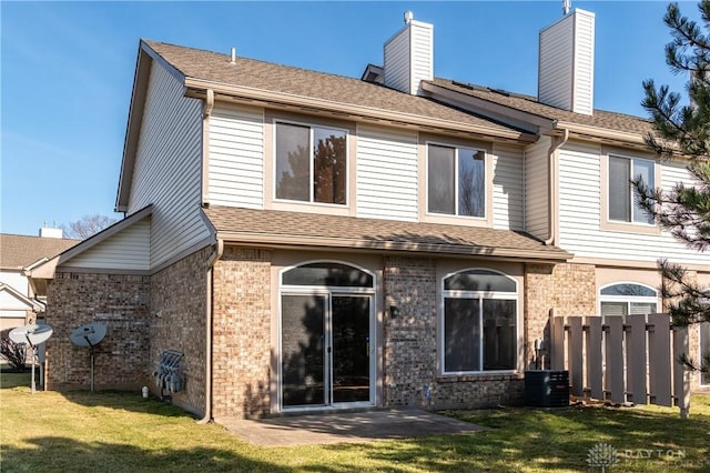 rear view of property featuring a yard and central AC