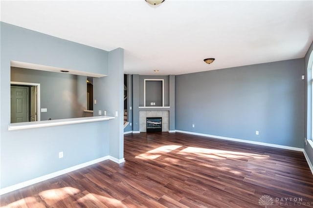 unfurnished living room with dark hardwood / wood-style flooring and a fireplace