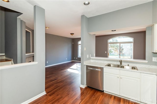 kitchen with sink, white cabinets, stainless steel dishwasher, light stone counters, and dark wood-type flooring