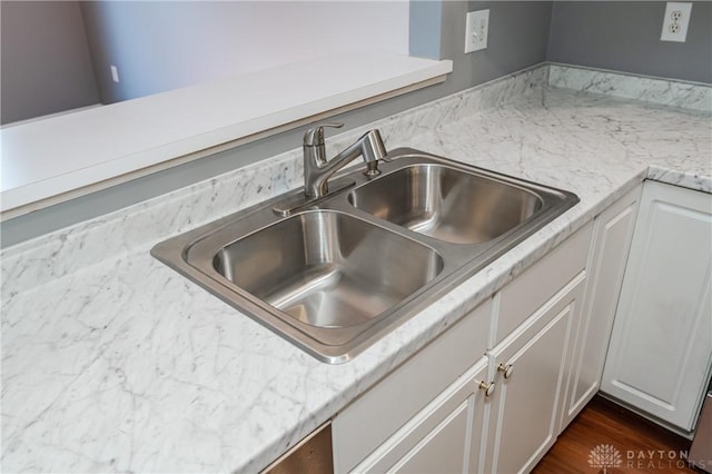 interior details with white cabinetry, sink, and dark wood-type flooring