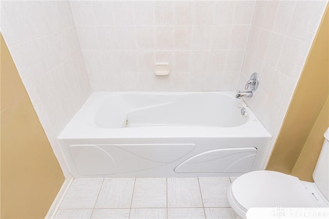 bathroom with a tub to relax in, toilet, and tile patterned flooring