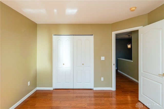 unfurnished bedroom with hardwood / wood-style floors and a closet