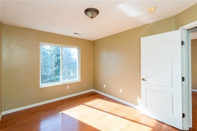 spare room featuring wood-type flooring