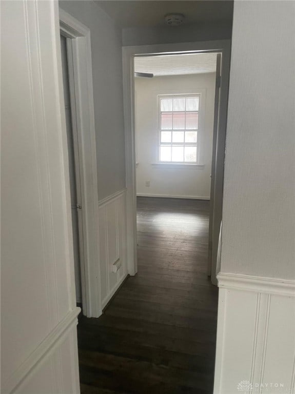 hallway with dark hardwood / wood-style flooring