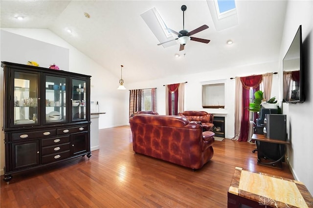 living room with wood-type flooring, a skylight, high vaulted ceiling, a wealth of natural light, and ceiling fan