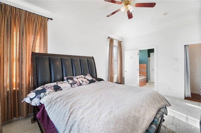 carpeted bedroom featuring ceiling fan and ensuite bath