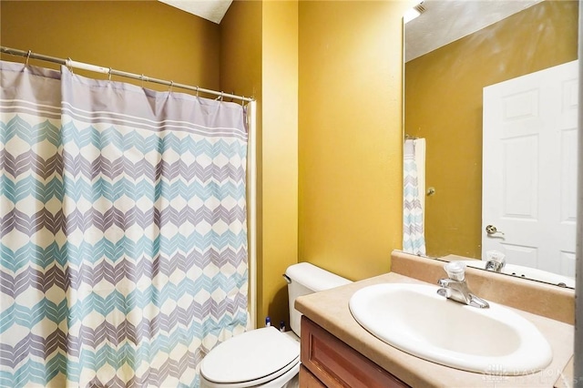 bathroom featuring vanity, toilet, and walk in shower