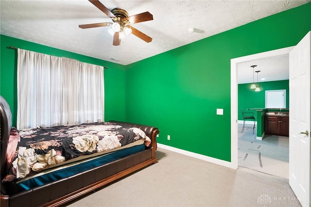 carpeted bedroom featuring ceiling fan and a textured ceiling