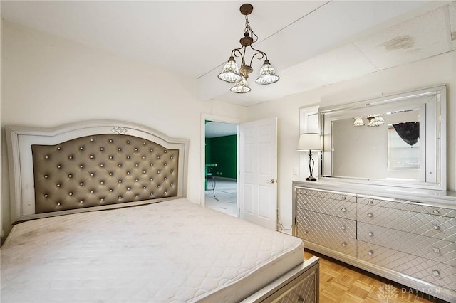 bedroom featuring an inviting chandelier and light parquet floors