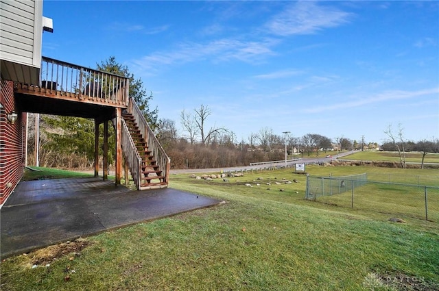 view of yard featuring a deck, a patio, and a rural view