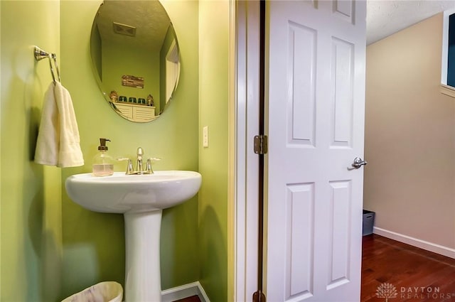 bathroom featuring sink, hardwood / wood-style floors, and a textured ceiling