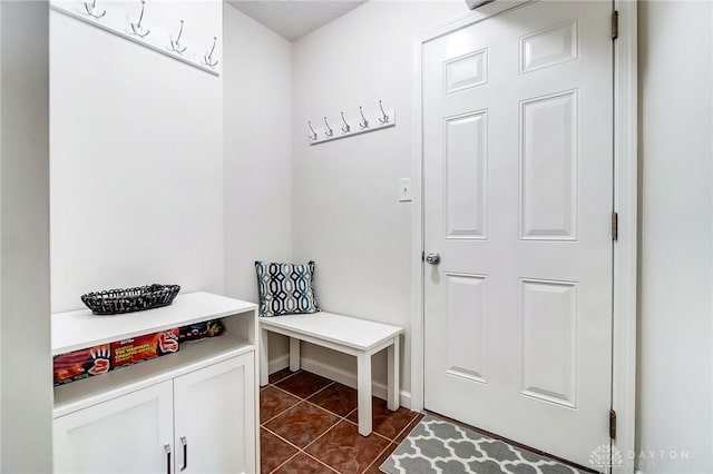 mudroom featuring dark tile patterned floors