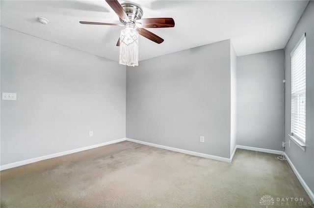 spare room with ceiling fan, a healthy amount of sunlight, and carpet