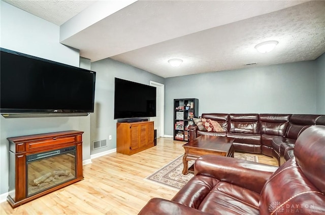 living room with light hardwood / wood-style flooring and a textured ceiling