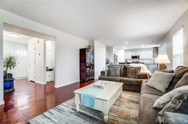 living room featuring plenty of natural light, a textured ceiling, and dark hardwood / wood-style flooring