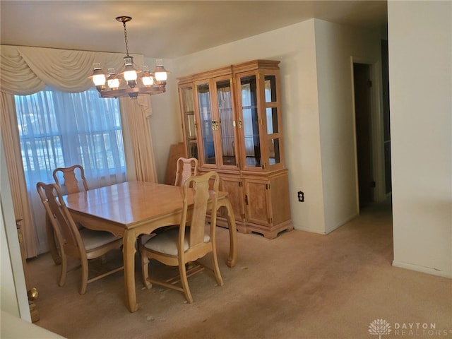 carpeted dining space featuring a notable chandelier