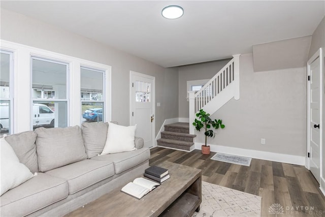 living room with a healthy amount of sunlight and dark wood-type flooring