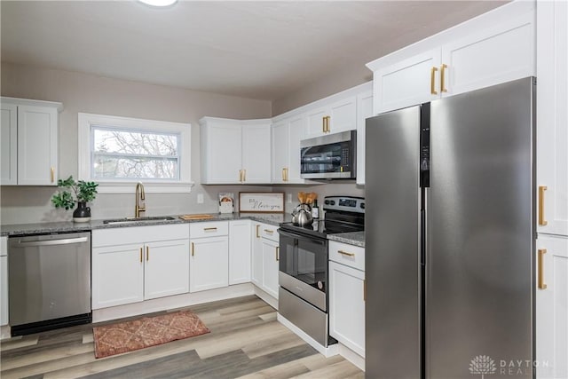 kitchen with stone countertops, sink, white cabinets, and appliances with stainless steel finishes