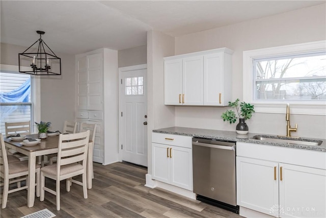 kitchen featuring sink, light stone counters, dishwasher, hardwood / wood-style flooring, and white cabinets