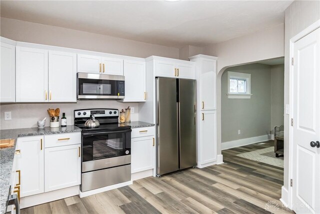 kitchen with light stone countertops, white cabinets, and appliances with stainless steel finishes