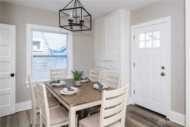 dining area with dark hardwood / wood-style flooring and a notable chandelier