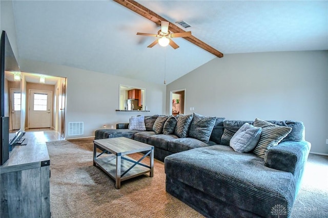 carpeted living room with ceiling fan and lofted ceiling with beams