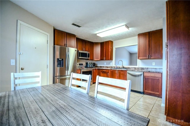 kitchen featuring light tile patterned flooring, appliances with stainless steel finishes, and sink