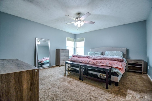 carpeted bedroom featuring ceiling fan and a textured ceiling