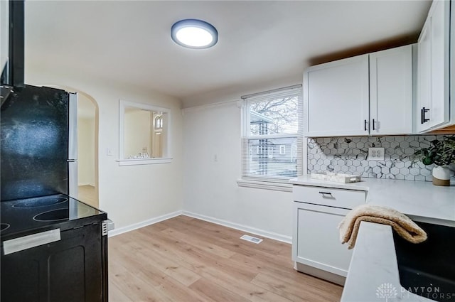 kitchen featuring white cabinetry, black range with electric cooktop, light hardwood / wood-style floors, and stainless steel refrigerator