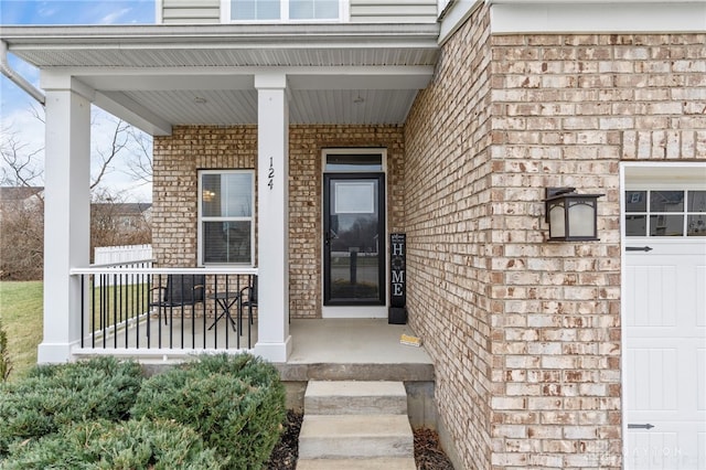 entrance to property featuring a porch and a garage