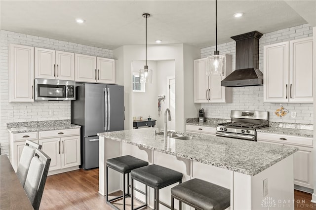 kitchen featuring sink, white cabinets, wall chimney exhaust hood, and appliances with stainless steel finishes