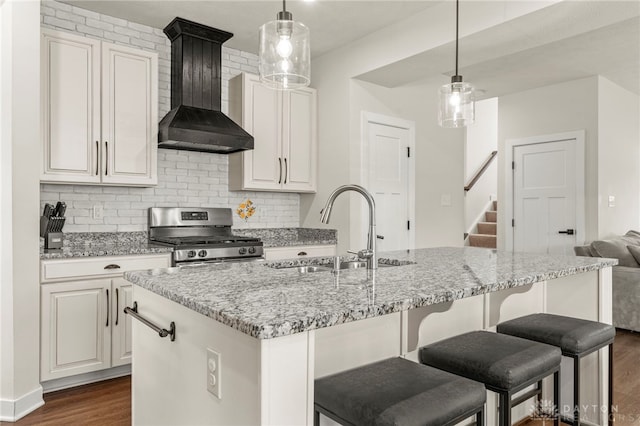 kitchen with premium range hood, sink, stainless steel gas range, and decorative light fixtures