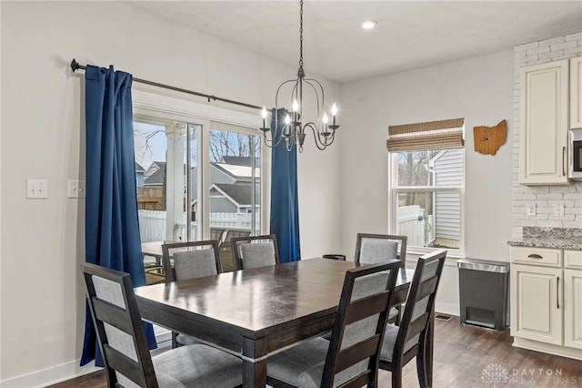 dining space featuring a notable chandelier, dark hardwood / wood-style floors, and a healthy amount of sunlight